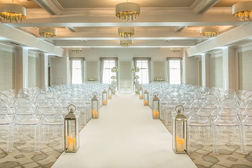 White ceremony aisle lined with lanterns at the Grand Connaught Rooms
