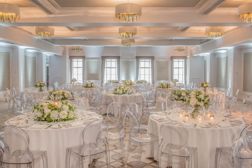Round tables dressed with white florals and tall candelabra
